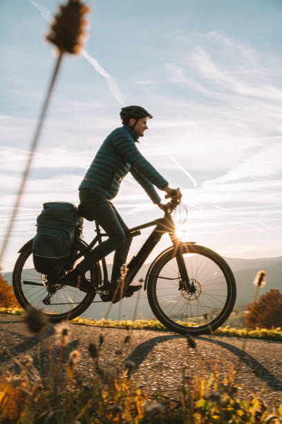 Young man rides e-mountain bike down road