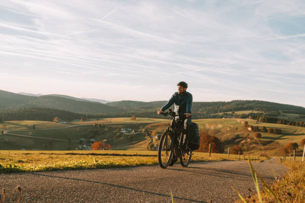 istock Young man rides e-mountain bike down road 1357153155