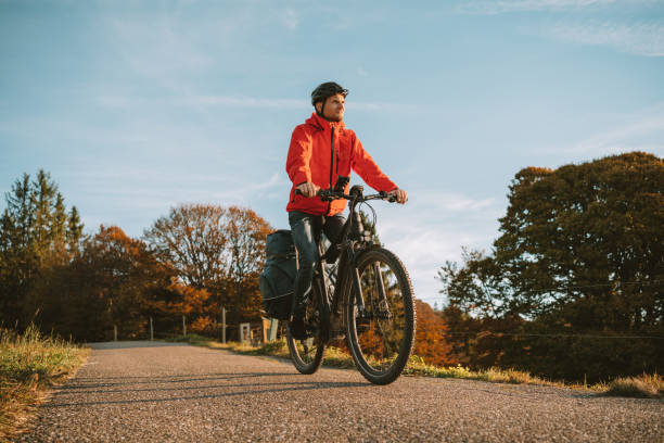 istock Young man rides e-mountain bike down road 1357153172