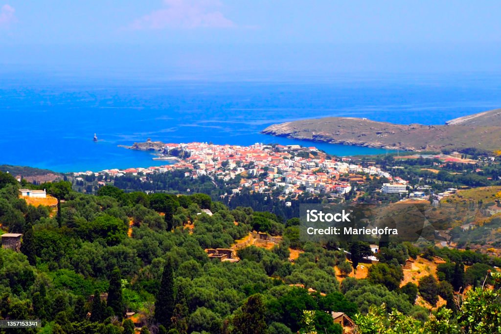 In the Cyclades, in the heart of the Aegean Sea : panoramic aerial view of the city of Chora, the largest city and capital of the island of Andros In the Cyclades, in the heart of the Aegean Sea : aerial view of the city of Chora, the largest city and capital of the island of Andros. Drone Stock Photo