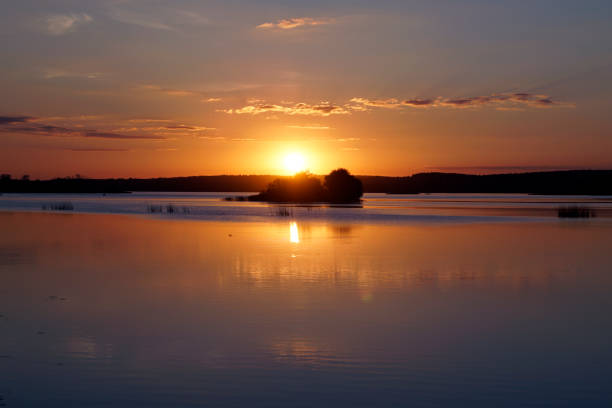 istock Quiet evening over the lake. Bright sunset and ducks on the water surface. 1357153450