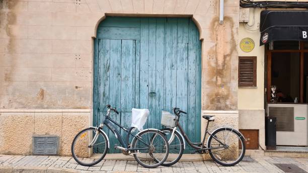 portão de entrada azul de uma casa com bicicletas clássicas em pollença - valldemossa - fotografias e filmes do acervo