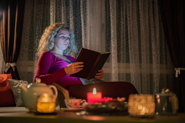 istock Woman reading a book at home 1357156133