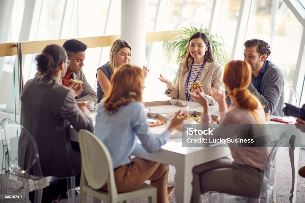 Group of young business people is enjoying a lunch break at the job together. Business, people, company Group of young business people is enjoying a lunch break at the job in a friendly atmosphere together. Business, people, company Lunch Stock Photo