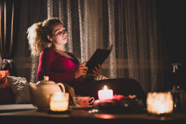istock Woman reading a book at home 1357158092