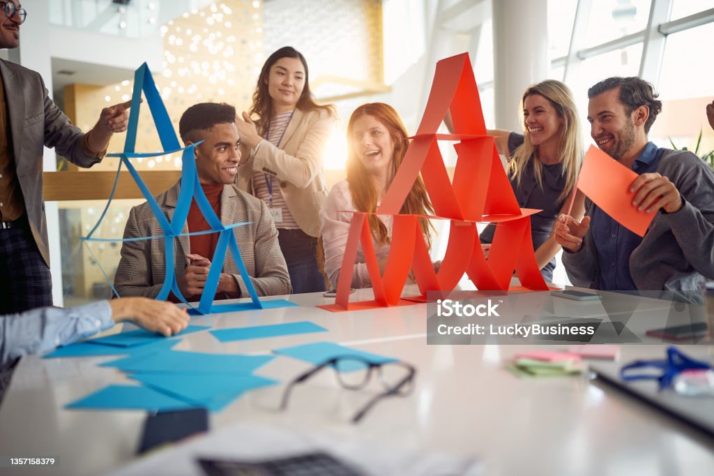 A group of young business people is enjoying team building games during a break at work. Business, people, company A group of young business people is enjoying team building games in a cheerful atmosphere during a break at work. Business, people, company Team Building Stock Photo