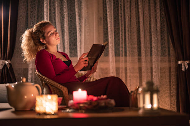 istock Woman reading a book at home 1357159773