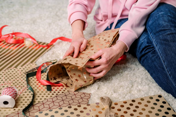 istock Women's hands wrap a gift in craft paper. Craft packaging handmade, gift boxes for birthdays, Valentine's Day, New Year or Christmas 1357163075