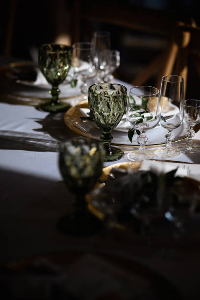 istock Various glass glasses on a white table in a dark key 1357165340