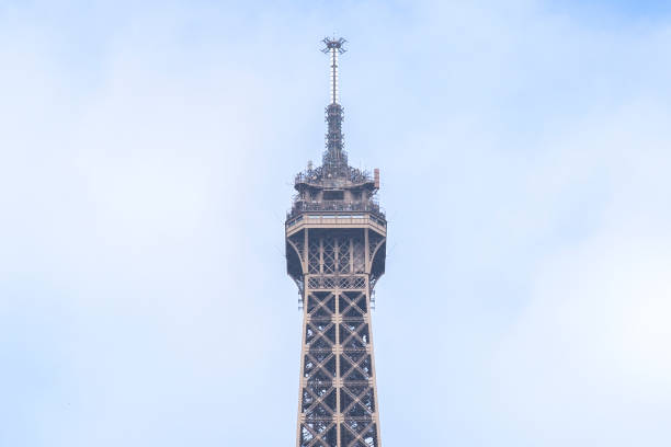 париж эйфелева башня вершина крупным планом - famous place eiffel tower clear sky urban scene стоковые фото и изображения