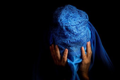 Sad Afghan Woman wearing a burka looking down