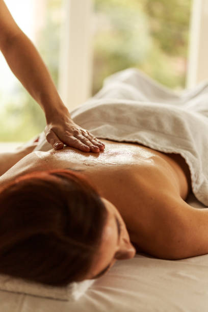 istock Applying oil on a spa client's back 1357168418