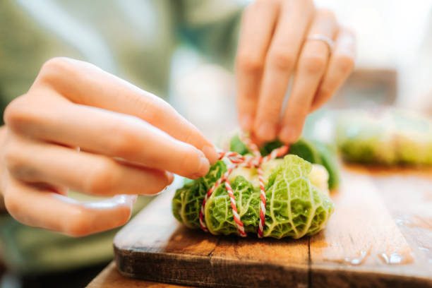 istock Close-up of a woman hands making stuffed Christmas cabbage rolls 1357169290
