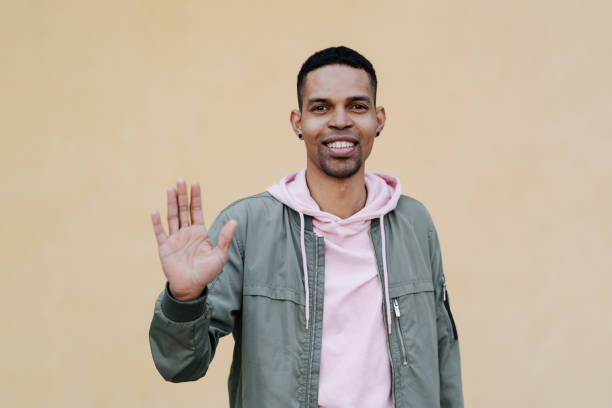 istock Afro Man showing hello over yellow pale background 1357170763