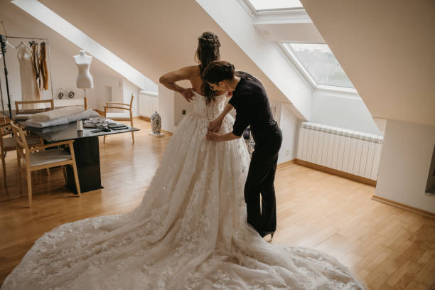 istock Bride in bridal studio trying wedding dress with her tailor 1357173284