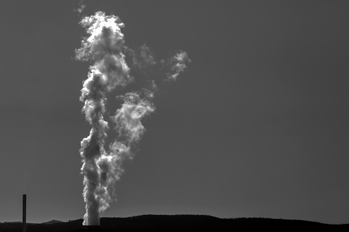 Dark black and white Air pollution, power station smoke from chimney, background with copy space, full frame horizontal composition