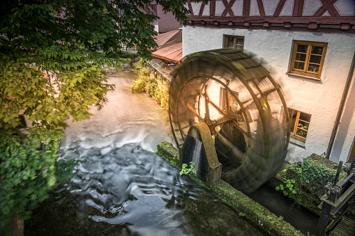 Old disused paddle mill with rusted iron wheel near a canal in the Po Valley in Piedmont, Italy