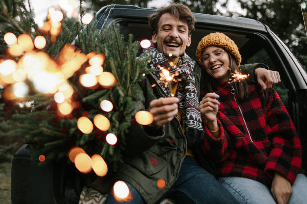 istock Couple having fun with sparkle on Christmas tree adventure 1357179885