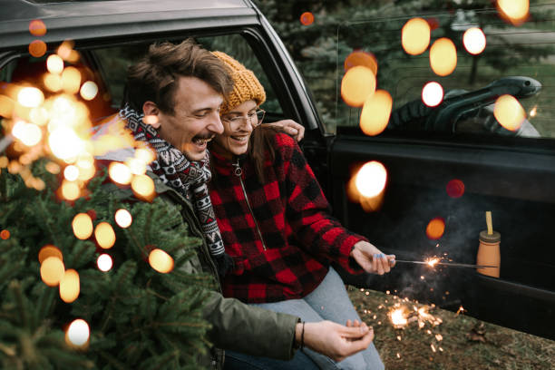 istock Couple having fun with sparkle on Christmas tree adventure 1357179888