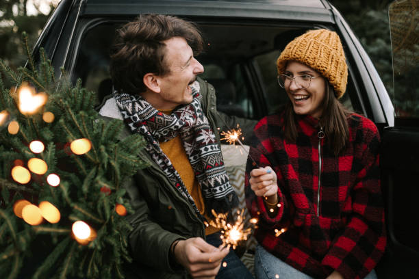 istock Couple having fun with sparkle on Christmas tree adventure 1357179924