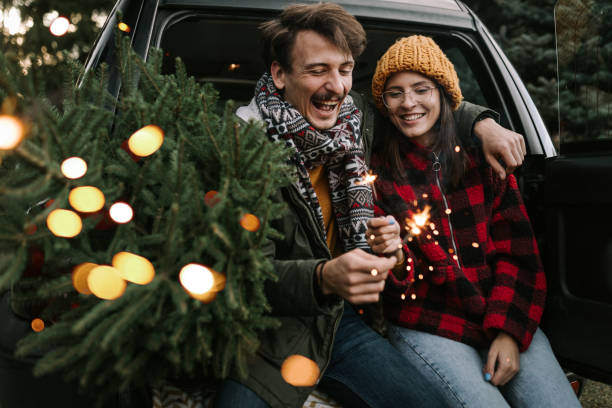 istock Couple having fun with sparkle on Christmas tree adventure 1357180449