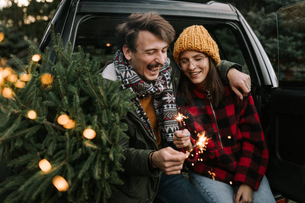 istock Couple having fun with sparkle on Christmas tree adventure 1357180468