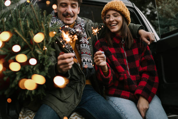 istock Couple having fun with sparkle on Christmas tree adventure 1357180485