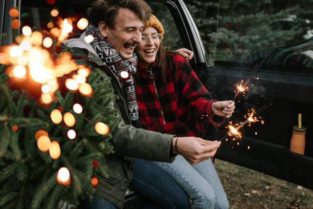 istock Couple having fun with sparkle on Christmas tree adventure 1357180498
