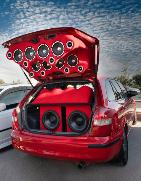 nagłośnienie składające się z wielu głośników zainstalowanych w tylnej bagażniku czerwonego samochodu. - car stereo zdjęcia i obrazy z banku zdjęć