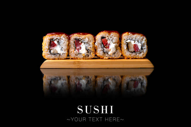 istock Hot tempura eel sushi roll with reflection isolated on black background ready food banner with text space 1357181863
