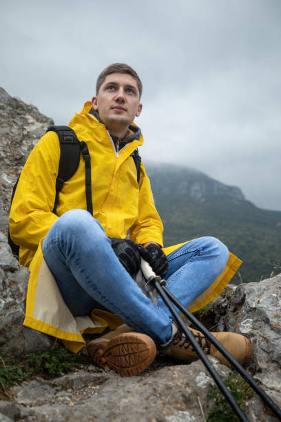 istock Hiker sitting on rocks on mountain peak 1357182712