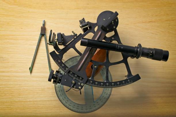 istock Vintage nautical sextant with protractor and dividers set on navigation chart table 1357188678