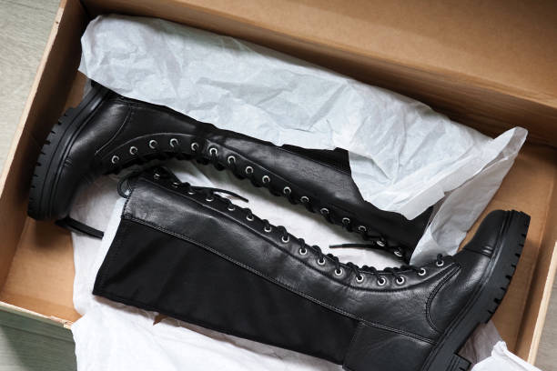 New black leather modern female lace-up boots inside box on wooden floor, top view. Pair of stylish high boots New black leather modern female lace-up boots inside box on wooden floor, top view. Pair of stylish high boots lace up stock pictures, royalty-free photos & images