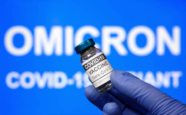 Omicron COVID-19 variant and corona virus vaccine, focus on vaccine vial stock photo