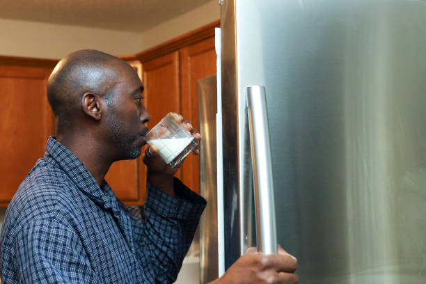 A portrait of a black African-American man drinking a glass of milk stock photo