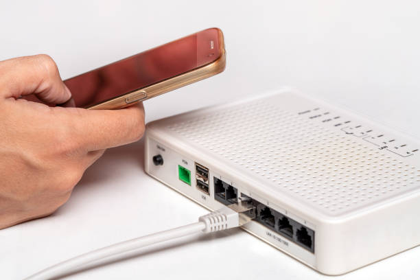 スマートフォンを使用してルーターと男。wi-fiのコンセプト - 有線wifi ストックフォトと画像