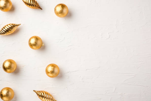 istock Christmas gold bauble ball decoration on white pastel table background 1357214527