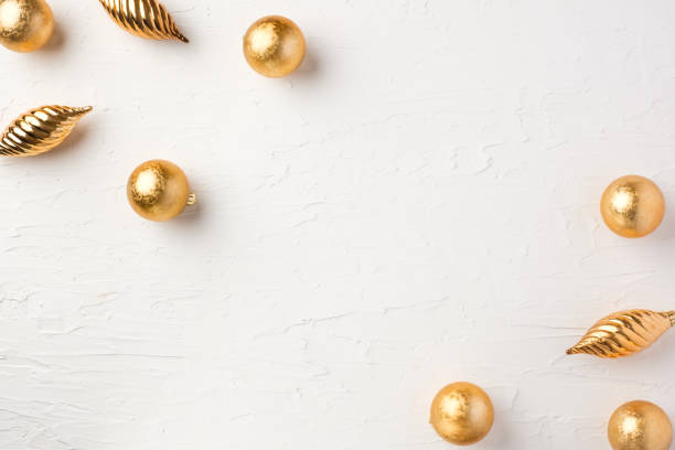 istock Christmas gold bauble ball decoration on white pastel table background 1357214539