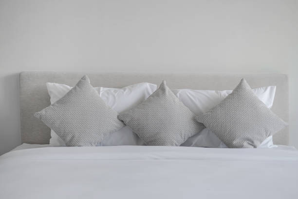 A bed with a cosy fur blanket and various pillows.