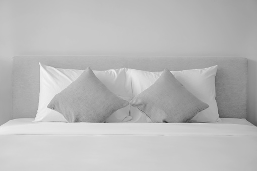 Shot of clean pillows neatly arranged on a double bed of a hotel suite.