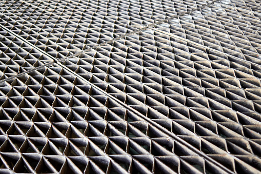 Metal industry steel grate sheet. Shallow depth of field diminished perspective industrial grates profiled drainage latticed metal flooring for floor grating, at petrochemical plant.