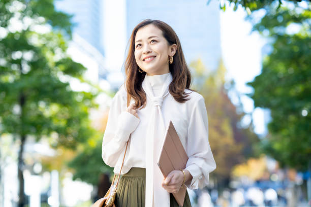 オフィスカジュアルスタイルで通勤する女性 - 日本人　笑顔 ストックフォトと画像