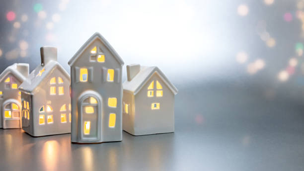 istock little toy white houses with burning lights inside. christmas decorations on abstract light background. 1357230747
