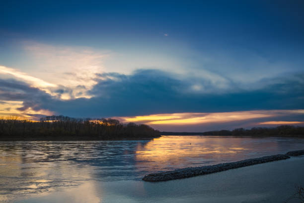 istock Beautiful sunset on Missouri River in late autumn; setting sun reflecting in water 1357230920