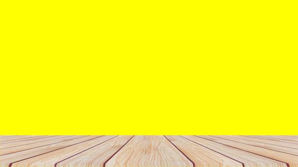 istock Wooden table on yellow background 1357233926