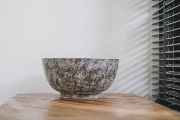 Side view shot of a beautiful ceramic bowl above wooden kitchen counter at home.