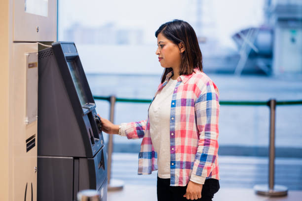 Young woman withdrawing money from ATM using Debit Card. Young Asian/Indian woman withdrawing money from ATM using Debit Card. banks and atms stock pictures, royalty-free photos & images