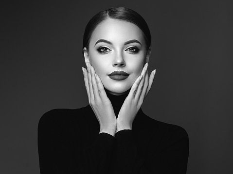 Beautiful Young Woman with Clean Fresh Skin. Perfect Makeup. Beauty Fashion. Cosmetic Eyeshadow. Girl in Black Turtleneck. Black and white photo