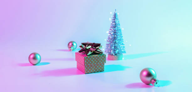 istock Christmas composition neon. Holiday decoration bauble ball on neon gradient backdrop. Minimal abstract tree, xmas gift box. New year banner. 1357239118