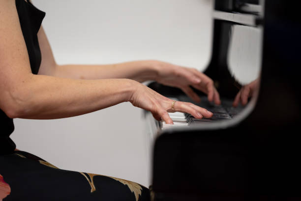 istock Female hands playing piano, close-up photo 1357240879